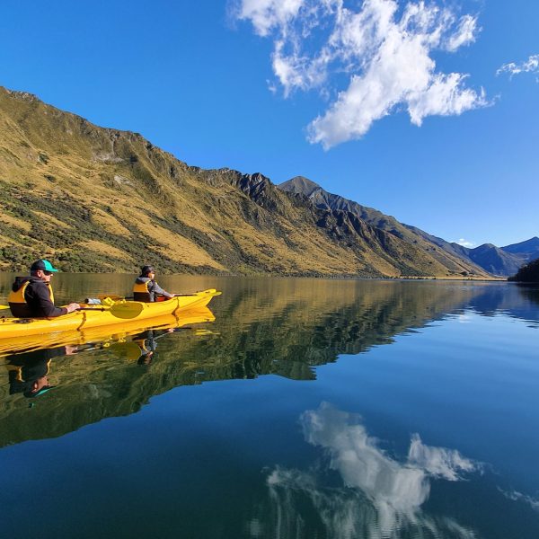 a small boat in a body of water with a mountain in the background