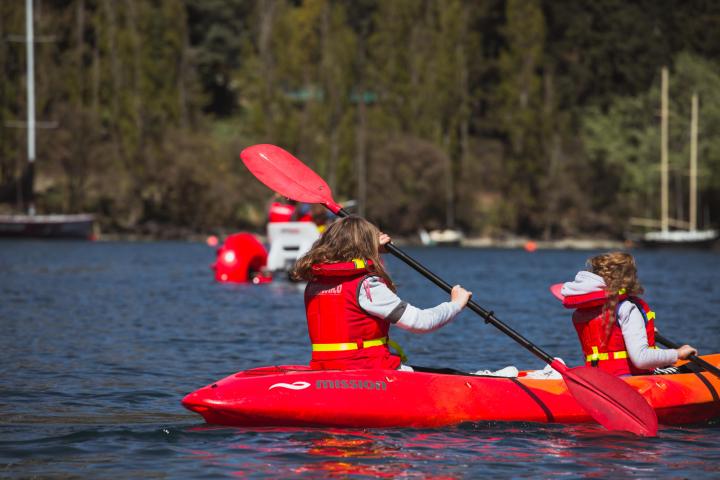 a man riding on the back of a red boat on the water