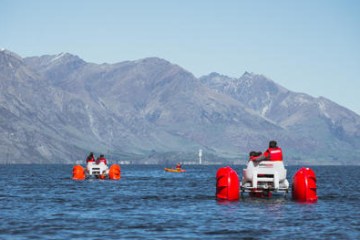 a small boat in a body of water with a mountain in the background