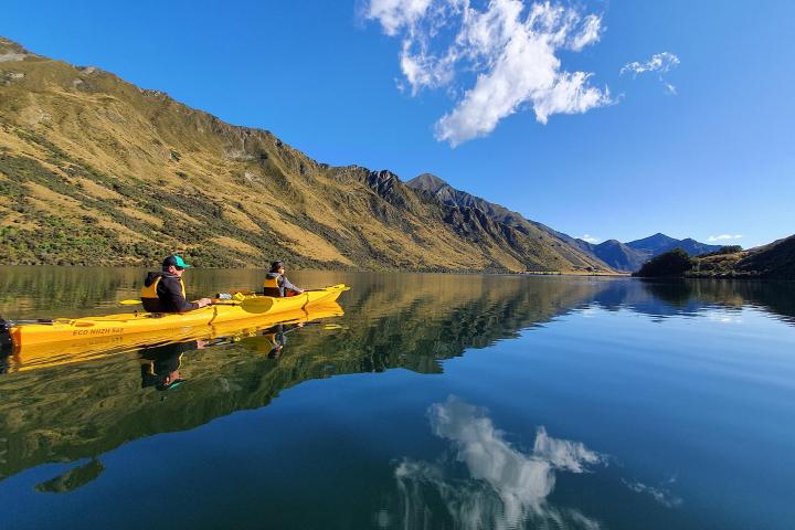 a small boat in a body of water with a mountain in the background