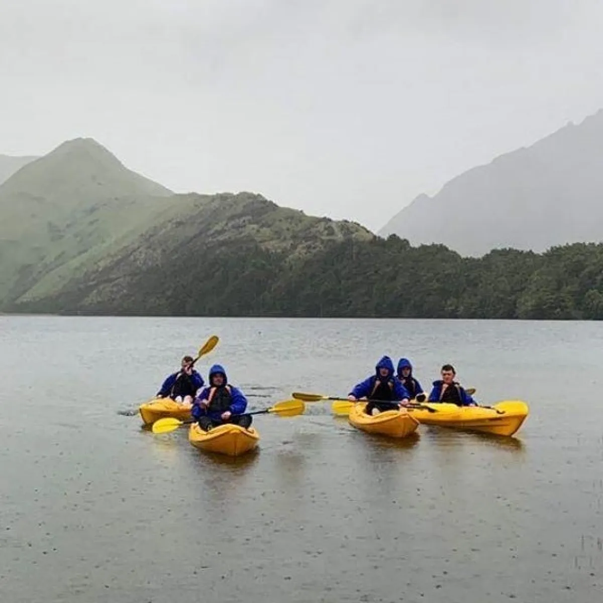 a group of people riding on the back of a boat in the water