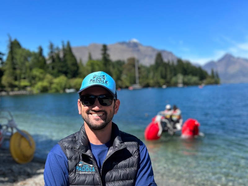 a man standing next to a body of water
